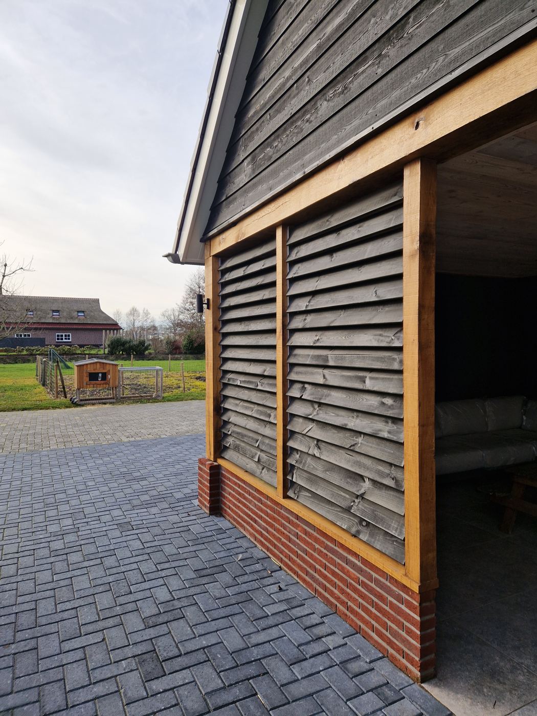 Gevel met houten lamellen tussen de staanders