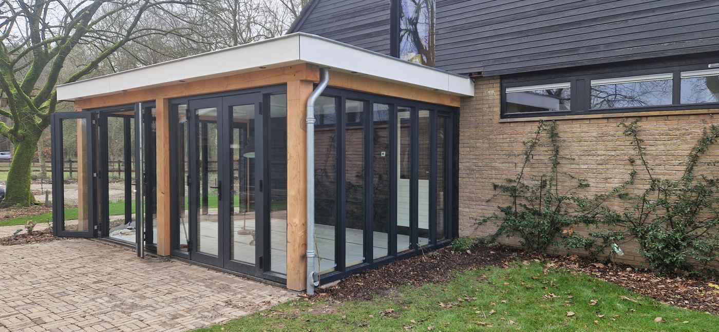 Hoek van de tuinkamer met geopende schuifdeuren