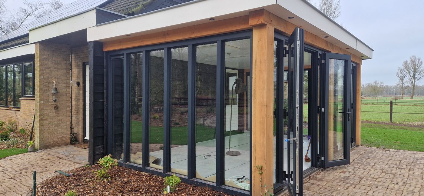 Glazen pui van de tuinkamer langs de bestaande gevel